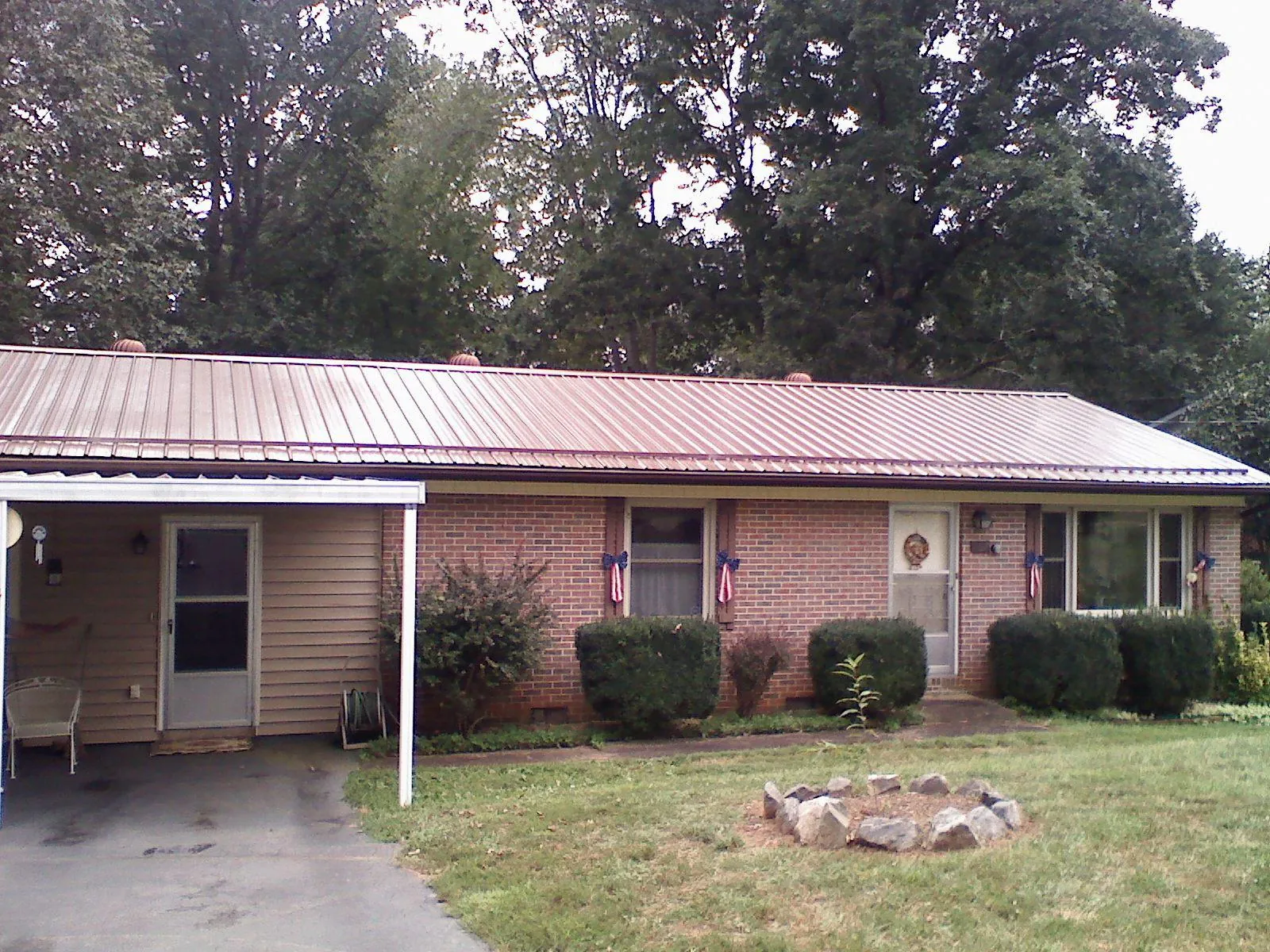 Bronze metal roof and carport on a brick ranch home — Roof Repair work by our crew in Ardenvoir